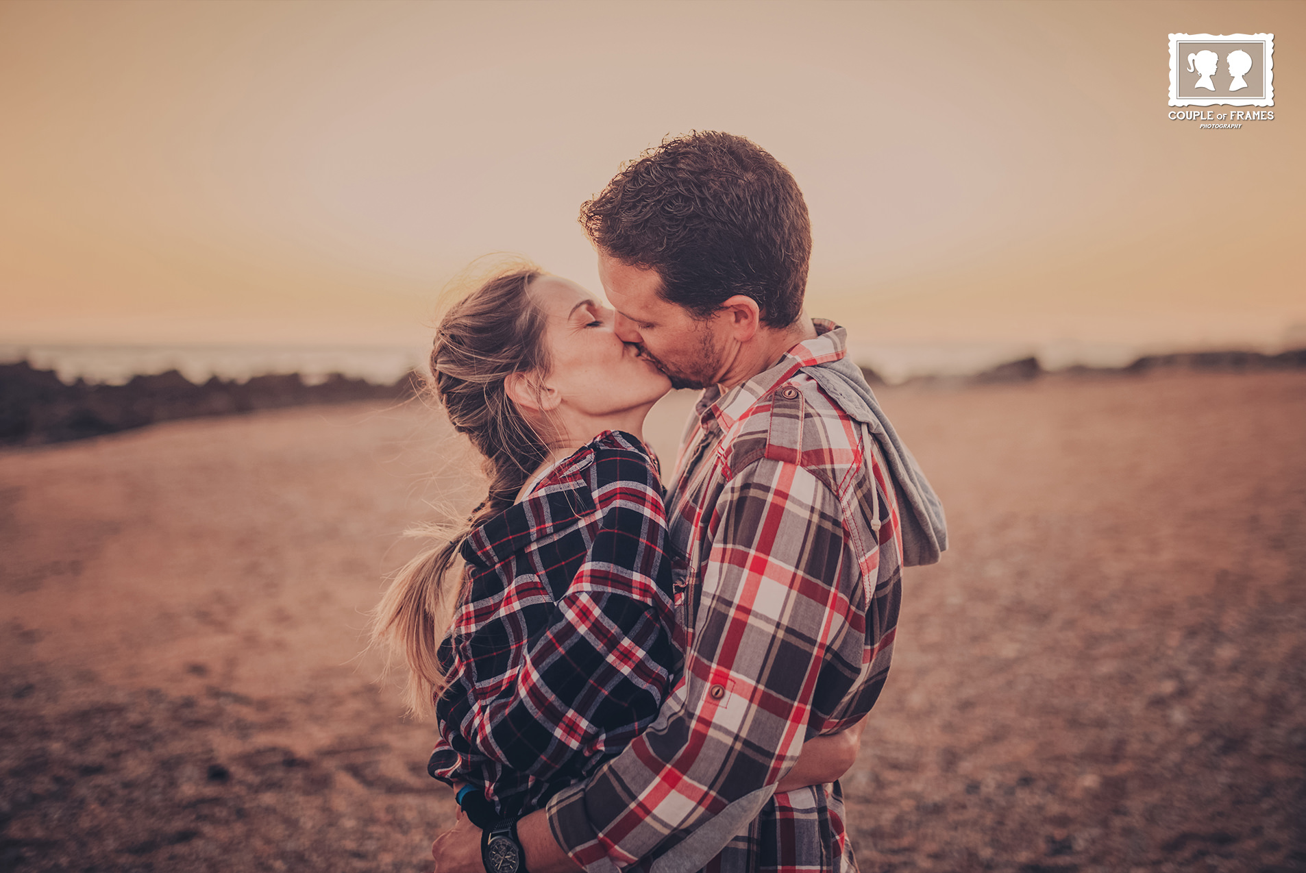Casal junto a uma casa de madeira na neve