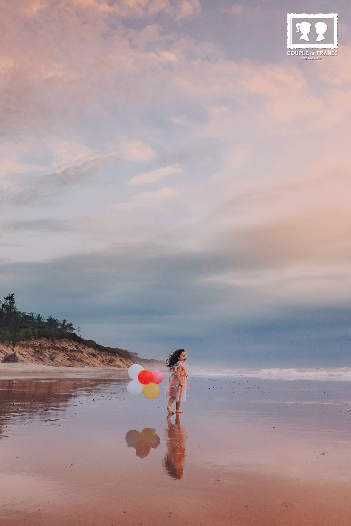 Uma criança a brincar na praia com balões